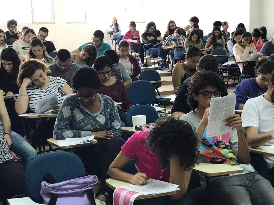 Estudantes em sala de aula atentos à uma prova que estão fazendo